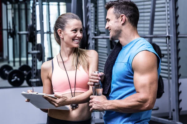 Kvinnliga tränare diskutera med en muskulös man — Stockfoto