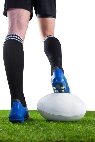 Rugby-Spieler posiert mit den Füßen auf dem Ball — Stockfoto