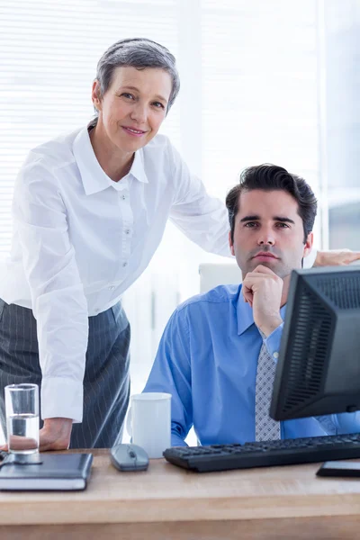 Porträt zweier Kollegen, die gemeinsam am Computer arbeiten — Stockfoto