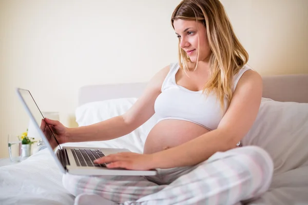 Mulher grávida usando computador portátil — Fotografia de Stock