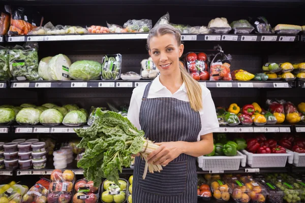 Söt blond kvinna håller vegetabiliska och tittar på kameran — Stockfoto