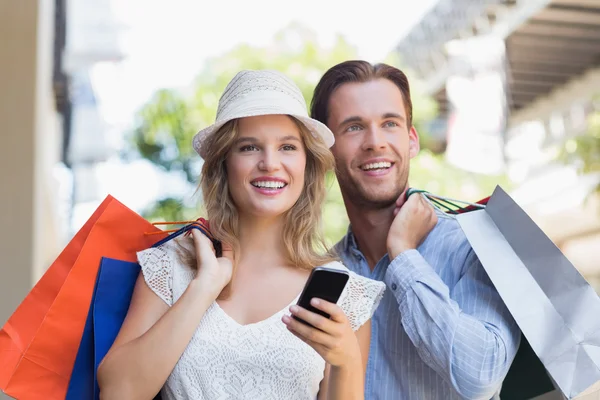 Cute couple holding shopping bags — Stock Photo, Image