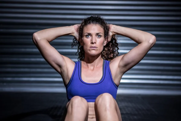 Gespierde vrouw sit-ups doen — Stockfoto