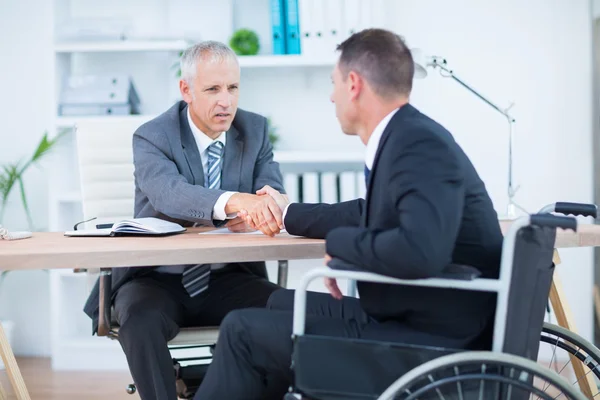 Affärsman i rullstol skakar hand med kollega — Stockfoto