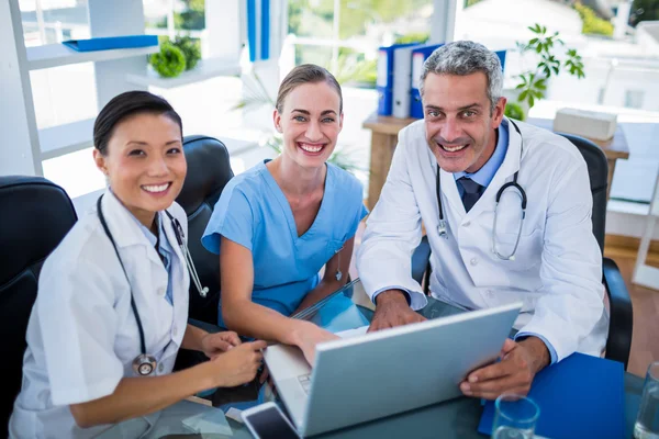 Artsen en verpleegkundige kijken naar laptop — Stockfoto