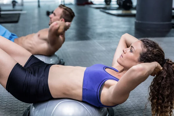 Casal fazendo exercícios de bola bosu — Fotografia de Stock