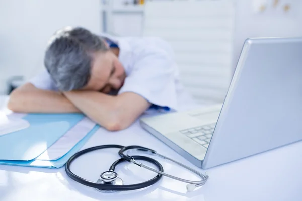 Médecin féminin dormant sur le bureau — Photo