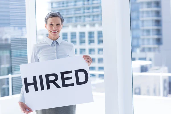 Businesswoman holding a signboard hired — Stock Photo, Image