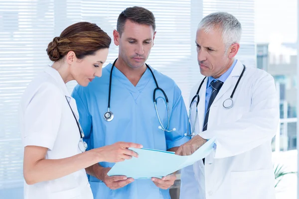 Concentrated medical colleagues analyzing file together — Stock Photo, Image