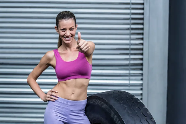 Lächeln muskulöse Frau gestikuliert Daumen hoch — Stockfoto