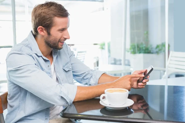 Jeune homme heureux tapant au téléphone — Photo