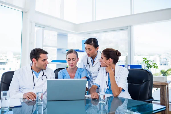 Team di medici che guardano il portatile — Foto Stock