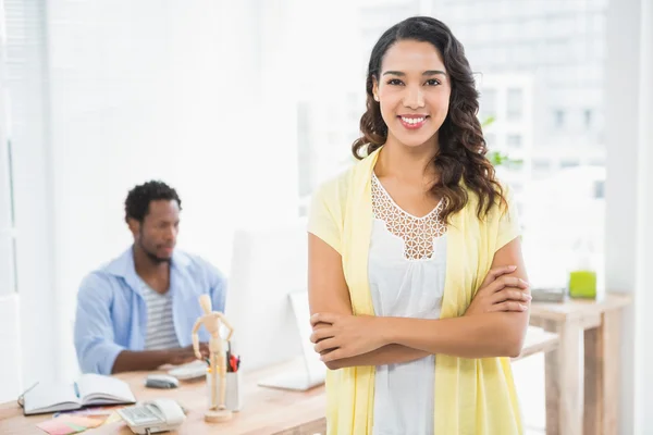 Smiling woman posing in front of her colleague with arms crossed — Stock Photo, Image