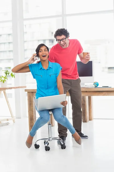 Smiling partners playing together with swivel chair — Stockfoto