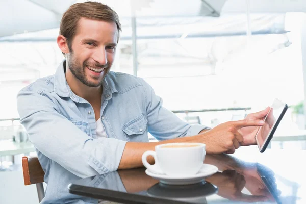 Mann lächelt und zeigt auf Tablet — Stockfoto