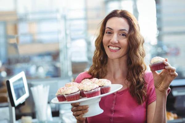 Söt brunett visar cupcake — Stockfoto