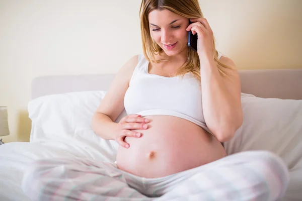 Gravid kvinna att ha telefonsamtal — Stockfoto