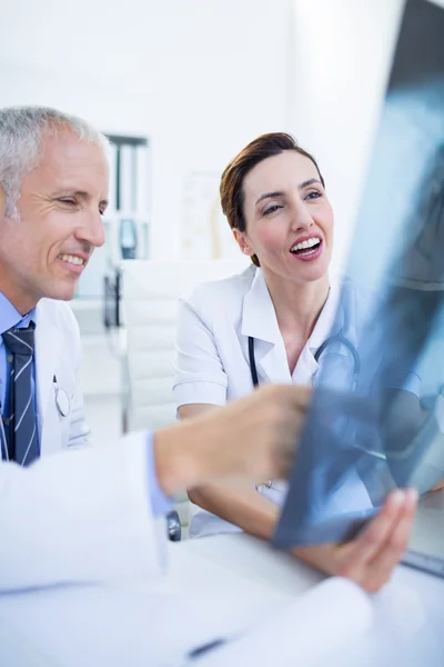 Smiling medical colleagues examining x-ray together — Stock Photo, Image