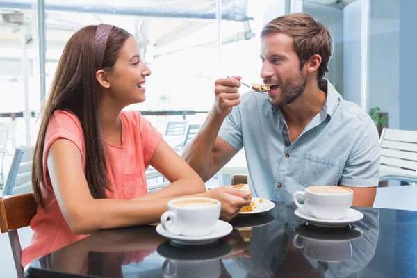 Happy couple eating cake together — Stockfoto