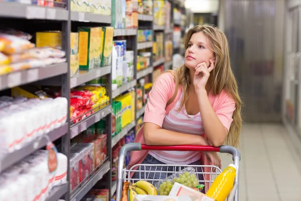 Žena při pohledu na polici v supermarketu — Stock fotografie