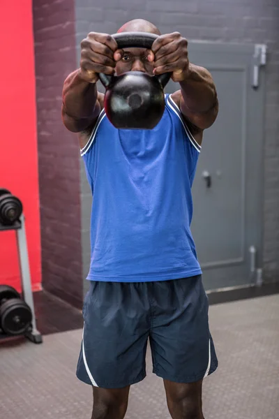 Homem muscular levantando um kettlebell — Fotografia de Stock