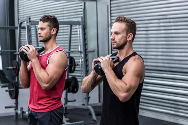 Homens musculosos exercitando com kettlebells — Fotografia de Stock
