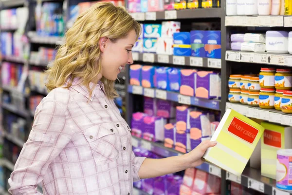 Mujer mirando un producto en el supermercado —  Fotos de Stock