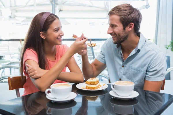 Happy couple eating cake together — Stockfoto