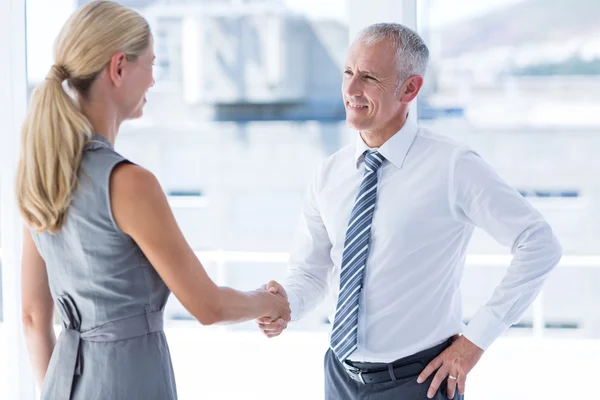 Twee glimlachend business mensen schudden handen — Stockfoto