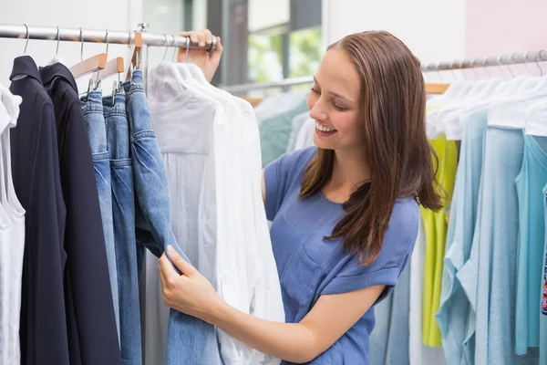 Pretty brunette browsing in the clothes rack — Stock Photo, Image