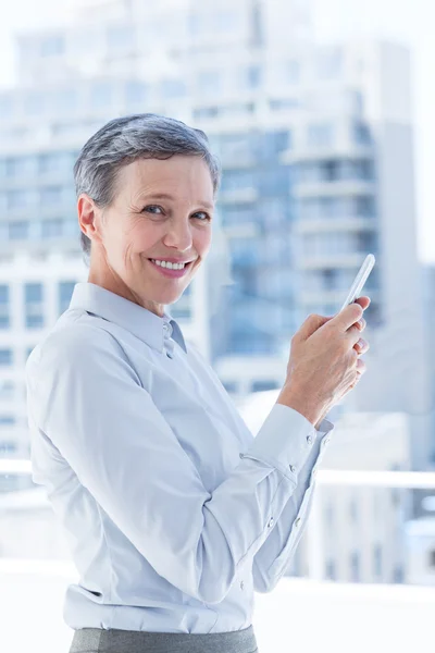 Geschäftsfrau verschickt SMS im Büro — Stockfoto