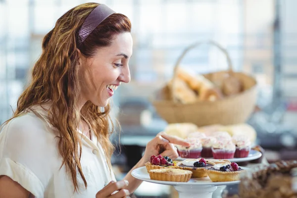 Sorpresa bella donna indicando torte — Foto Stock