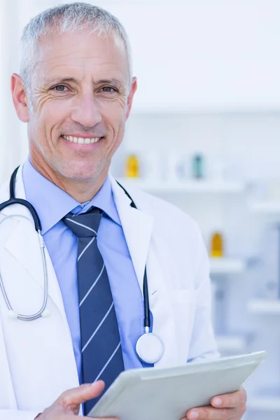 Médico olhando para a câmera e segurando prancheta — Fotografia de Stock