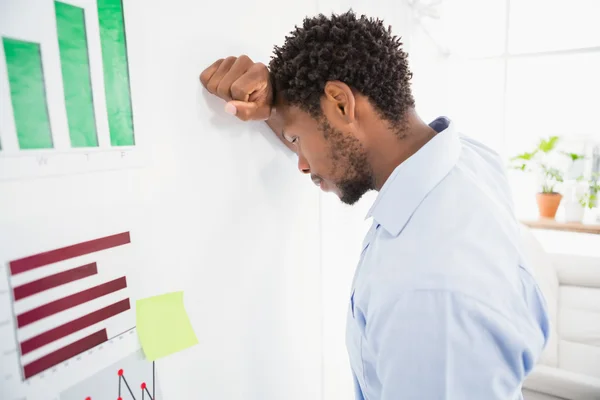 Thinking business man in the office leaning against the wall — Stock Photo, Image