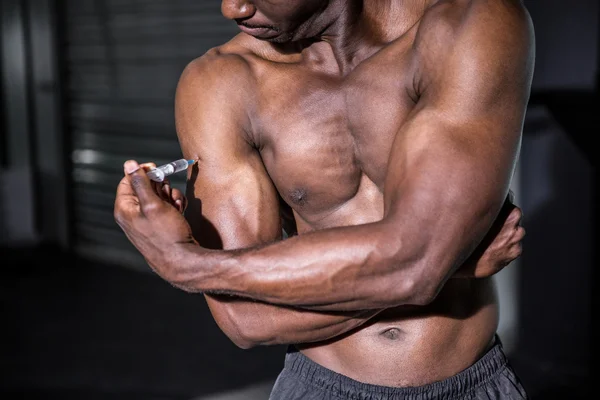 Joven culturista inyectándose algo en el brazo — Foto de Stock