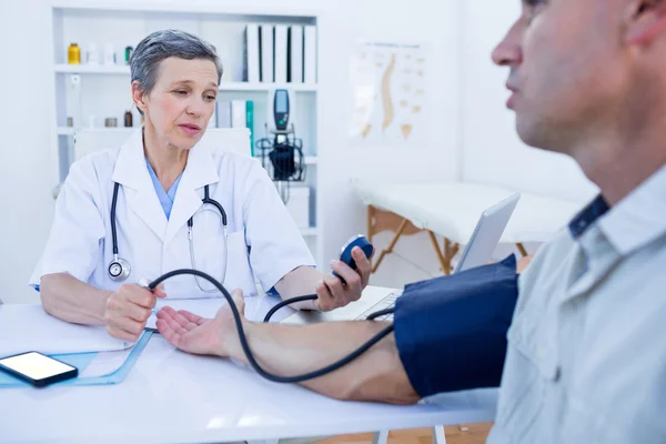 Doctor checking blood pressure of her patient — Stock Photo, Image