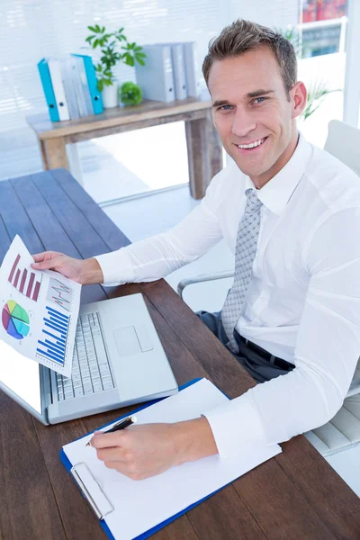 Hombre de negocios sonriente trabajando con diagramas de flujo —  Fotos de Stock