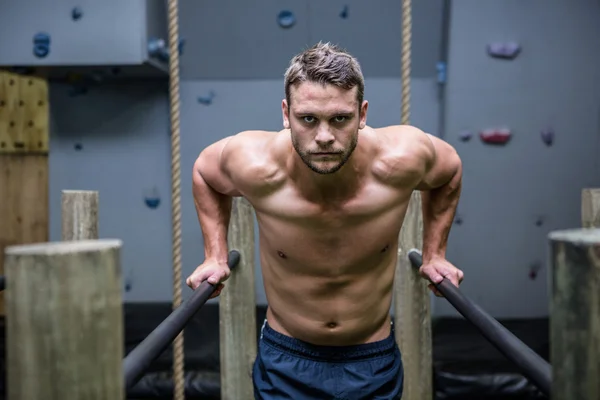 Retrato do homem muscular exercitando em barras paralelas — Fotografia de Stock