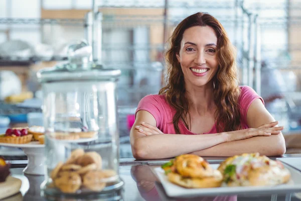 Brunette smiling behind counter — Stock Photo, Image