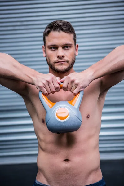 Retrato del hombre musculoso levantando una kettlebell —  Fotos de Stock