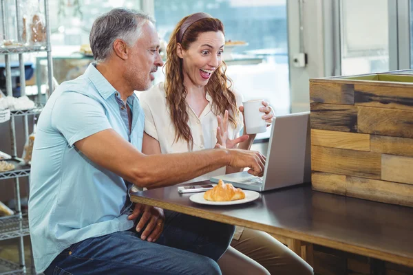 Lyckliga paret tittar på något roligt på laptop — Stockfoto