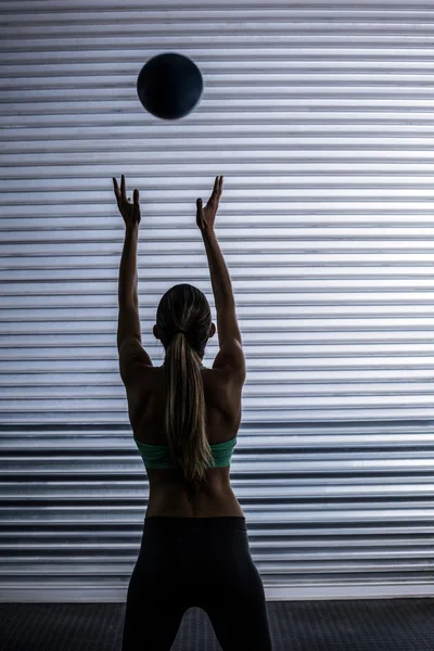 Muskulös kvinna kasta bollen i luften — Stockfoto