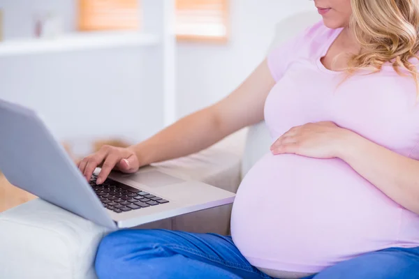 Mulher grávida usando seu laptop — Fotografia de Stock