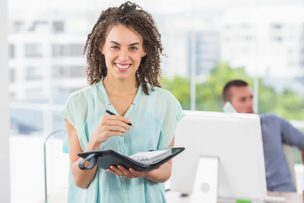Smiling businesswoman writing on a notebook — Stock Photo, Image