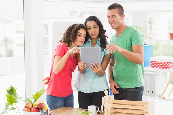 Equipe de negócios casual olhando para tablet juntos — Fotografia de Stock