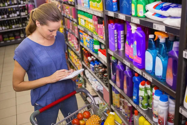 Pretty woman looking at her grocery list — Stock Photo, Image