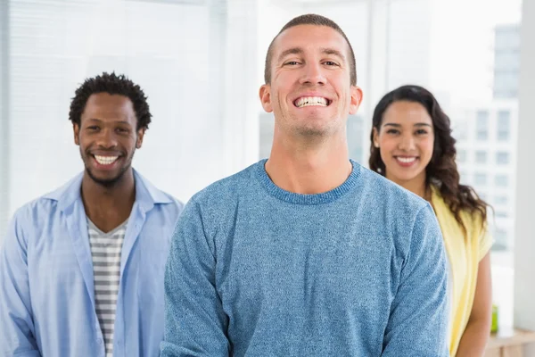 Sorrindo homem na frente de seus colegas olhando para a câmera — Fotografia de Stock