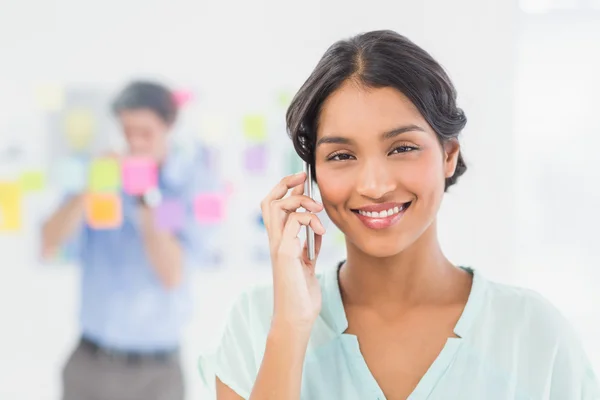 Businesswoman having phone call while her colleague posing — Stockfoto