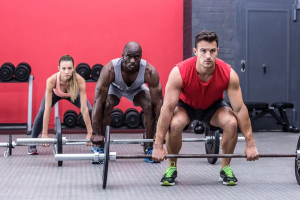 Três atletas musculares levantando sinos — Fotografia de Stock