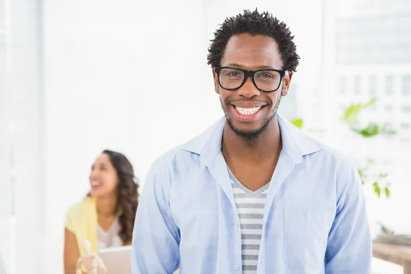 Hombre sonriente posando delante de su colega — Foto de Stock